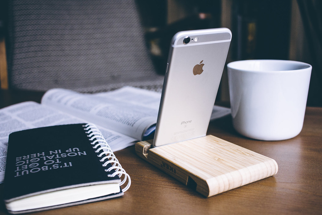 Phone resting upright in a wooden holder